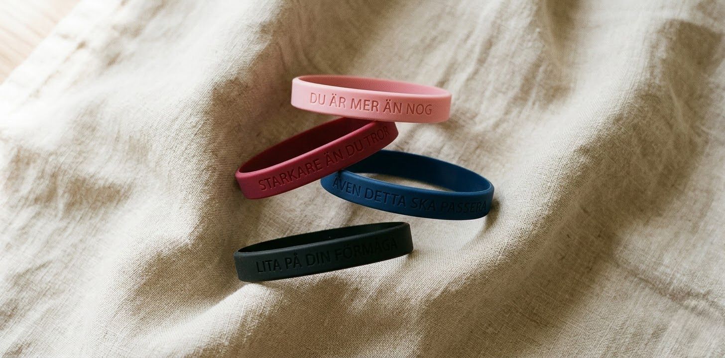 Fyra silikonarmband i rosa, mörkröd, mörkblå och svart